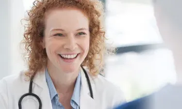 Women's health nurse practitioner smiling with patient during appointment